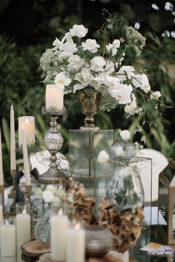 A white floral centrepiece on a styled reception table